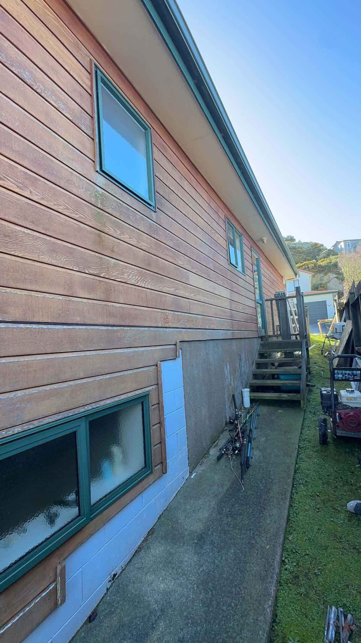 Severely faded cedar cladding before the project.